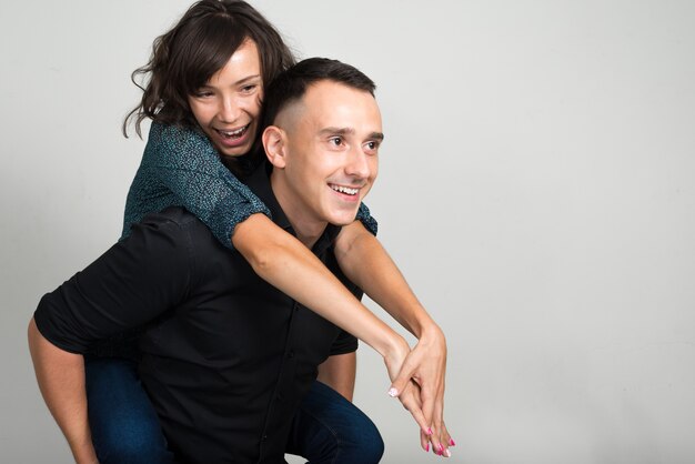 jonge man en jonge vrouw als paar samen en verliefd tegen witte muur