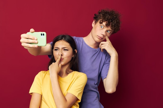 Jonge man en meisje moderne stijl emoties leuke telefoon rode achtergrond