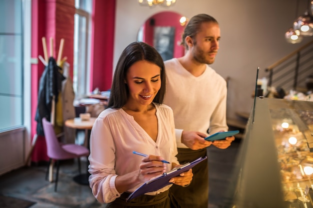 Jonge man en vrouw die in een bakkerij werken