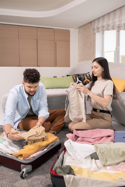 Jonge man en vrouw die koffers inpakken voordat ze op reis gaan