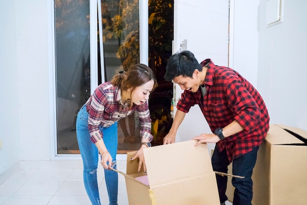 Jonge man en vrouw die samen karton openen