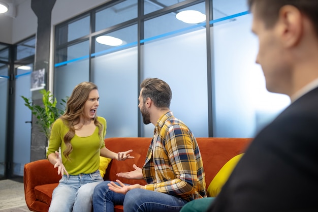 Jonge man en vrouw die tegen elkaar schreeuwen