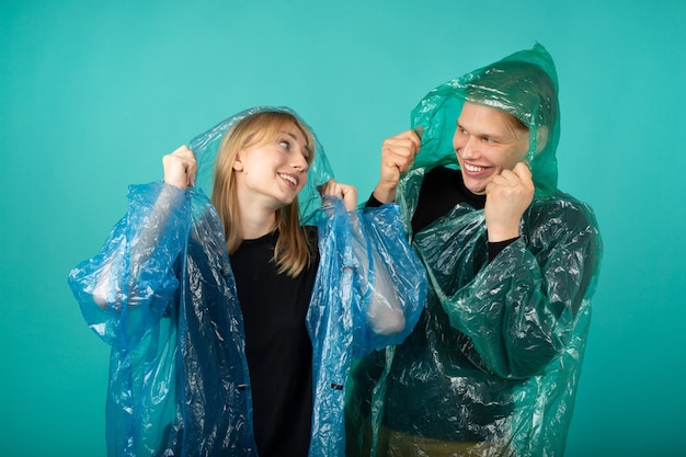 Jonge man en vrouw in regenjassen