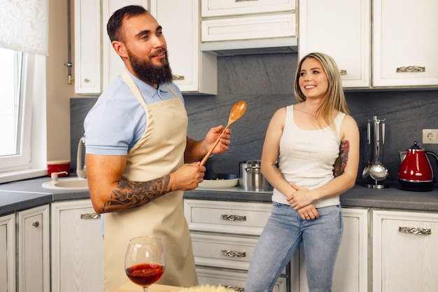 Jonge man en vrouw koken samen eten in de keuken gelukkig paar bereiden van voedsel