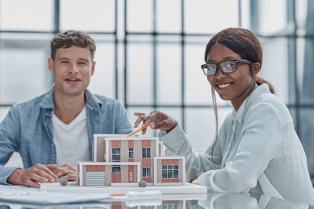 Jonge man en vrouw ontwerpers architecten bespreken huisontwerpen