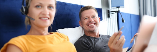 Jonge man en vrouw werken op afstand terwijl ze in bed liggen zakelijke introductie en ontwikkeling