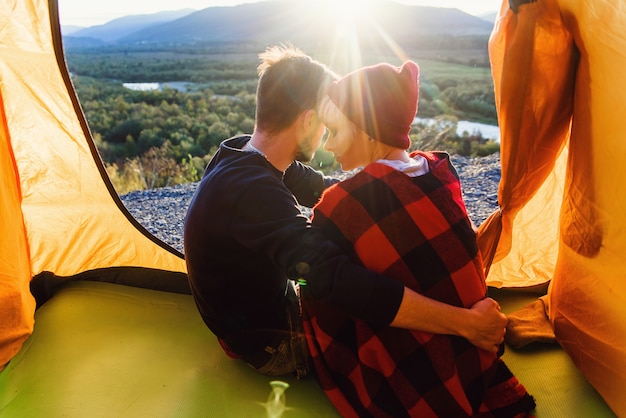 Jonge man en zijn vriendin zitten in de tent