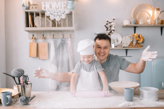 Jonge man en zijn zoon koken in de keuken