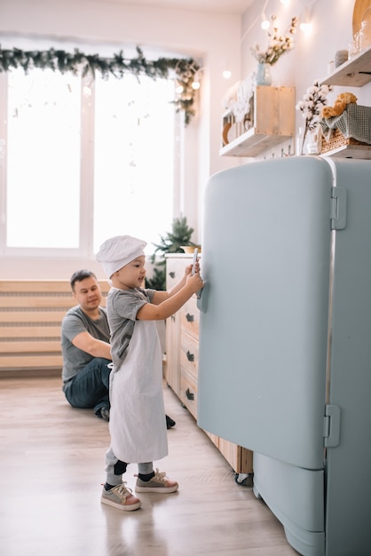 Jonge man en zijn zoon spelen in de keuken