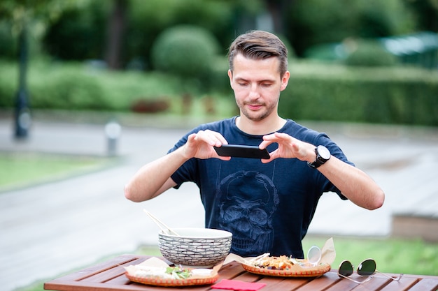 Jonge man eten haalt noedels op straat weg