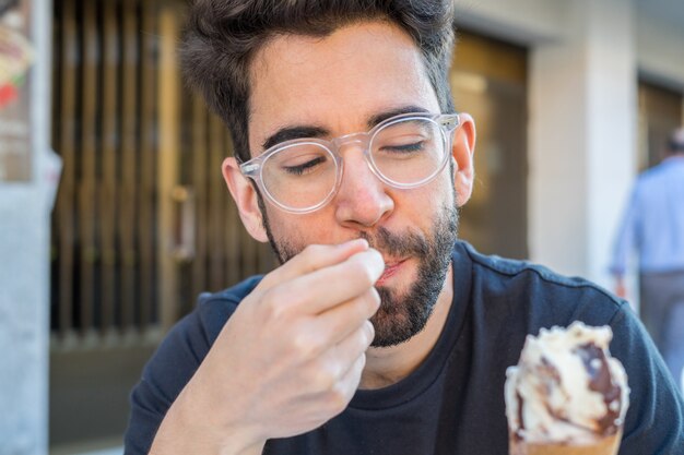 Jonge man eten van ijs