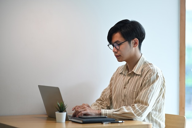 Jonge man freelancer online werken met laptopcomputer.