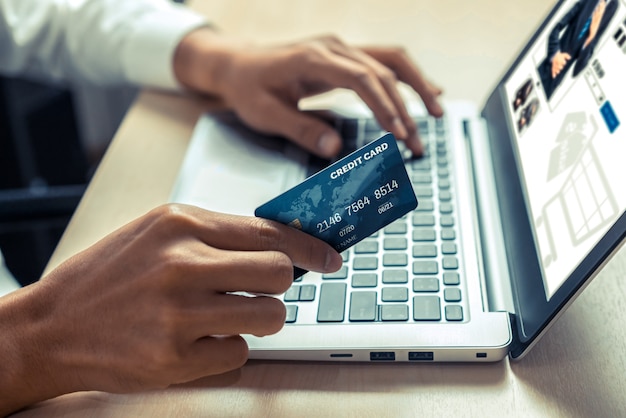 Jonge man gebruikt creditcard om online te winkelen