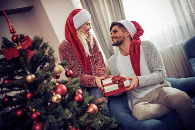 Jonge man geeft zijn vriendin kerstcadeau