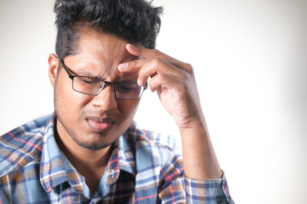 Jonge man gefrustreerd en lijden aan hoofdpijn, close-up.