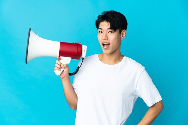 Jonge man geïsoleerd met een megafoon en glimlachen