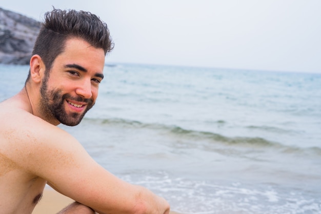 Jonge man gelukkig op het strand