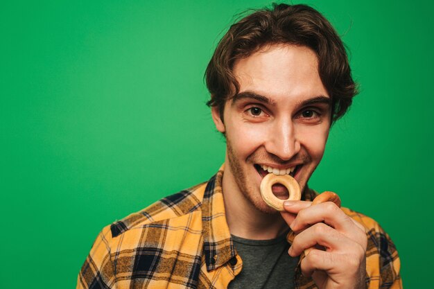 Jonge man geniet van het eten van koekje