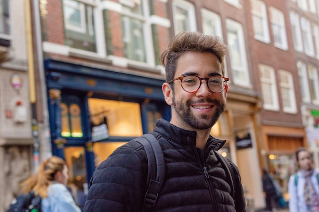 Jonge man glimlachend in de stad