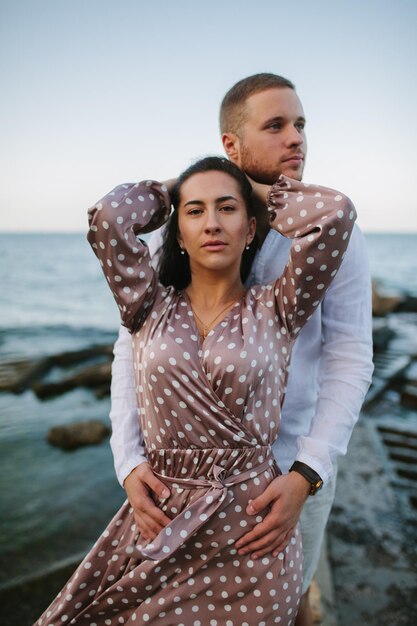 Jonge man houdt handen vast mooie jonge vrouw Paar brengt tijd door aan de kust Zomerzee goed humeur