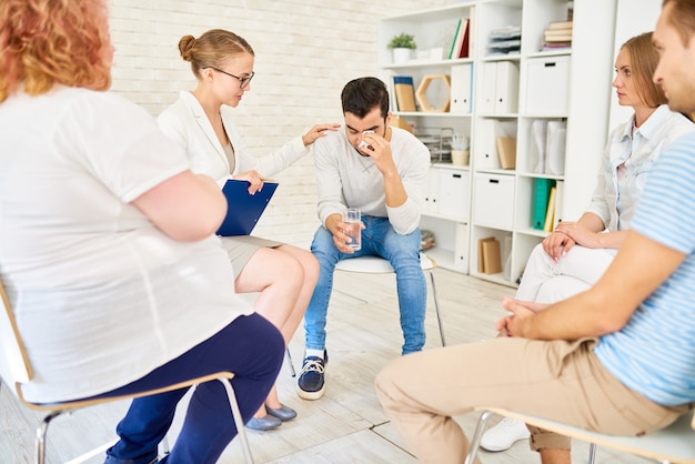 Jonge man huilen in groepstherapie