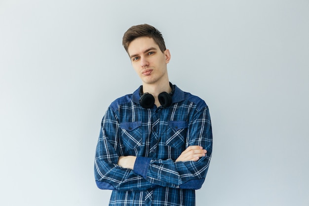 Jonge man in een blauw shirt op een lichtgrijze achtergrond. Werknemer en ondernemer