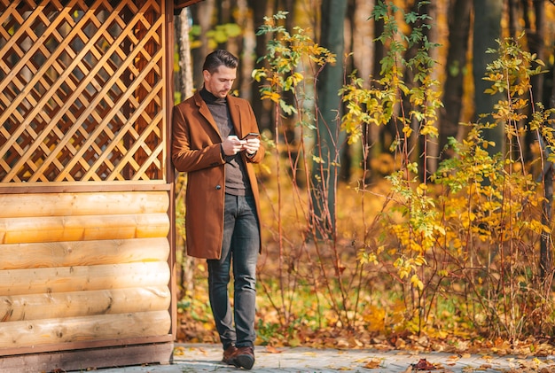 Jonge man in herfst park buiten spreidde zijn armen