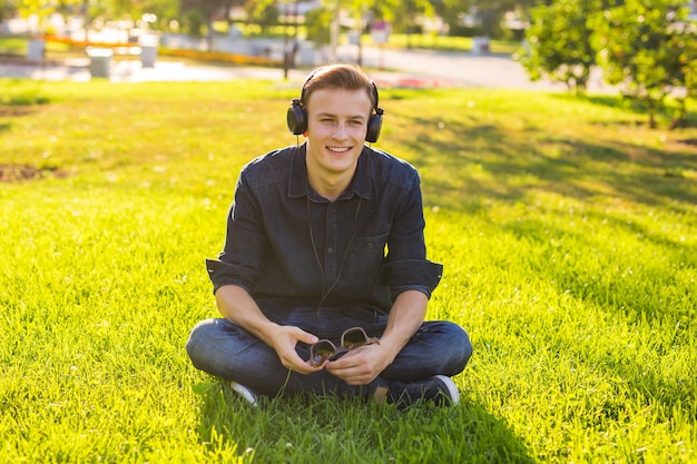 Jonge man in het park luisteren naar de muziek.