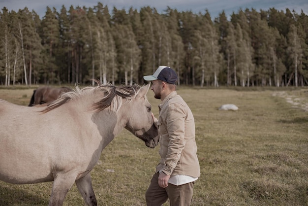 Jonge man in het veld met paard