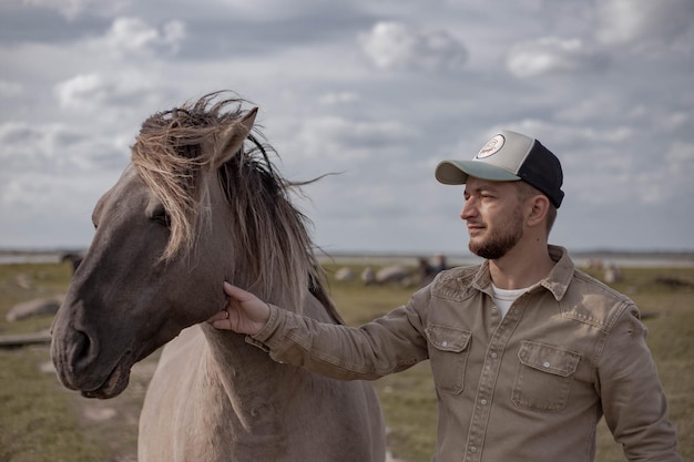 Jonge man in het veld met paard