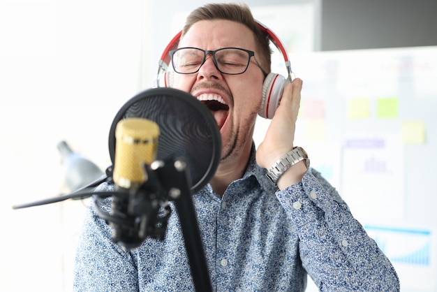 Jonge man in koptelefoon zingen in de microfoon