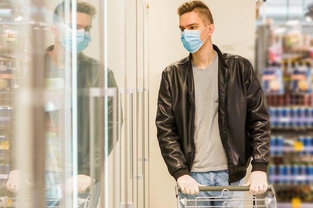 Jonge man in medische masker. quarantainebeveiliging. Man in de winkel