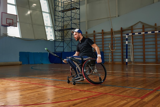 Jonge man in rolstoel tennissen op de baan