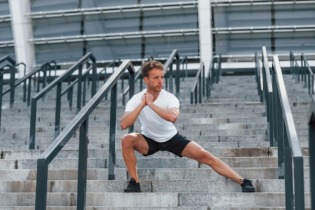 Jonge man in sportieve kleding traint overdag buiten