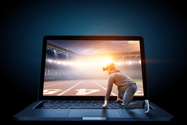 Jonge man in Vr-headset op start klaar positie op laptop. Gemengde media