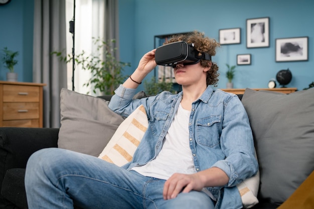 Jonge man in vrijetijdskleding draagt de virtual reality-bril kijkt en toont zich voorstellen via de