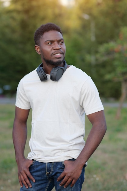 Jonge man in wit t-shirt wandelt en verkent de natuur in het park