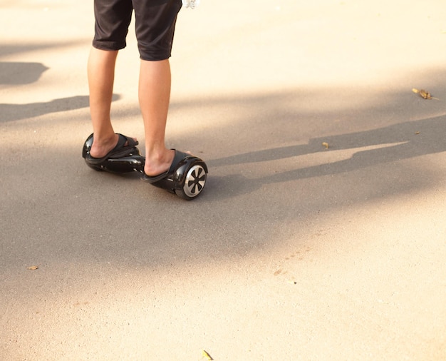 Jonge man in zwarte broek die een gyroskooter gebruikt op de weg