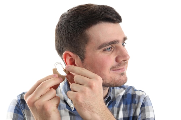 Jonge man installeren gehoorapparaat geïsoleerd op witte achtergrond