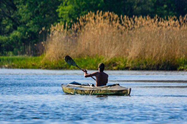 Foto jonge man kajaken op een rivier in de zomer