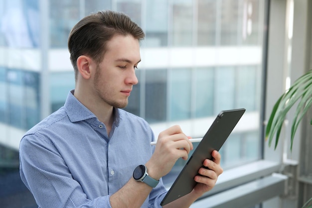 Jonge man kantoormedewerker of student gebruikt een tablet-computerapparaat met elektronische pen of potlood tekenen of schrijven