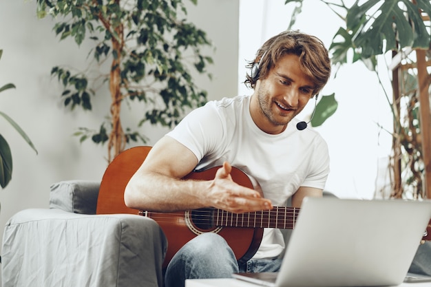 Jonge man kijken gitaar tutorial op zijn laptop