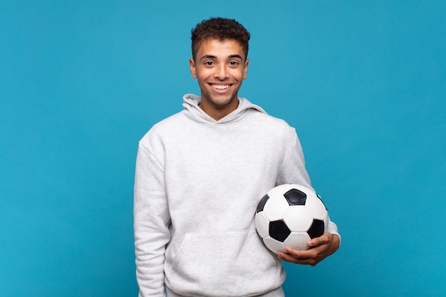 Jonge man kijkt blij en aangenaam verrast, opgewonden met een gefascineerde en geschokte uitdrukking. voetbal concept