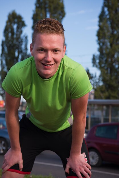 Jonge man kijkt naar de rest van het pad tijdens een pauze van zijn joggingtraining buiten