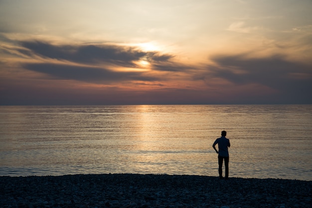 Jonge man kijkt naar de zonsopgang.