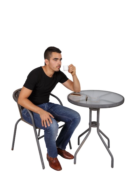 Jonge man koffie drinken aan een tafel op een witte achtergrond