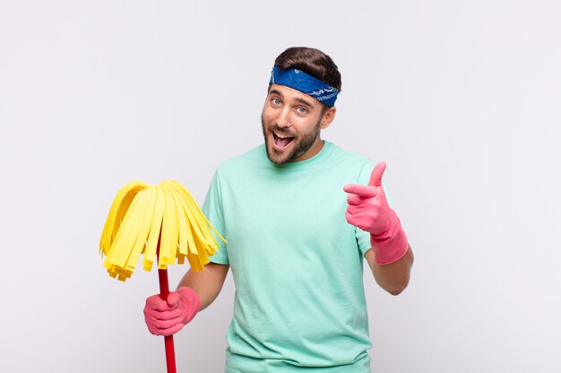 Jonge man lachend met een positieve, succesvolle, gelukkige houding wijzend naar de camera