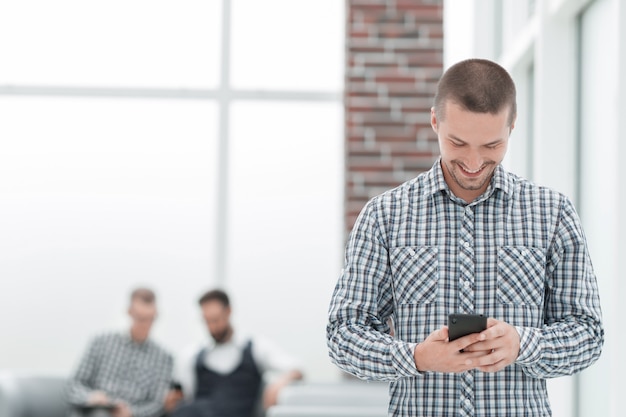 jonge man leest een sms op zijn smartphone. Mensen en technologie