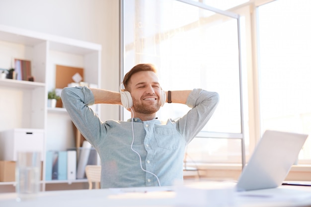 Jonge man luisteren naar muziek op het werk