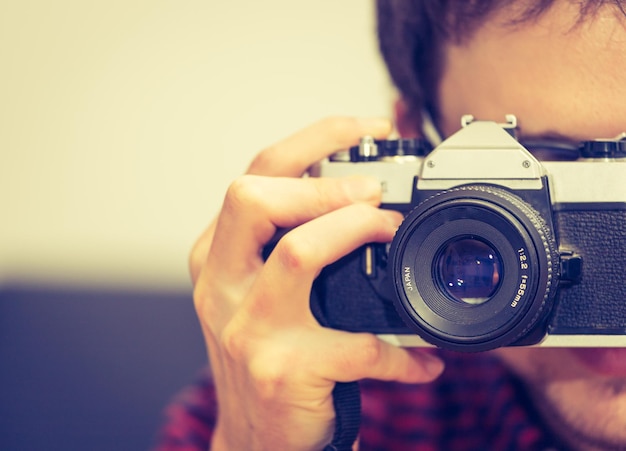 Jonge man maakt een foto met een vintage camera